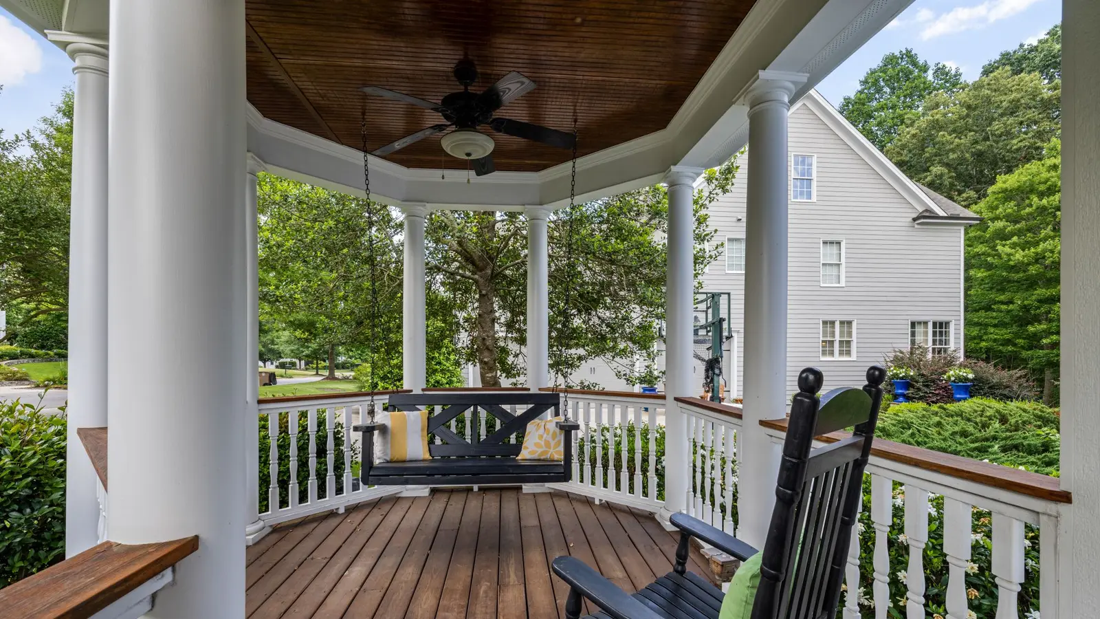 Porch with a hanging swing, a rocking chair and white columns